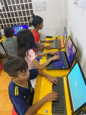 村の学習施設で、子どもたちが並んでノートパソコンに向かっている